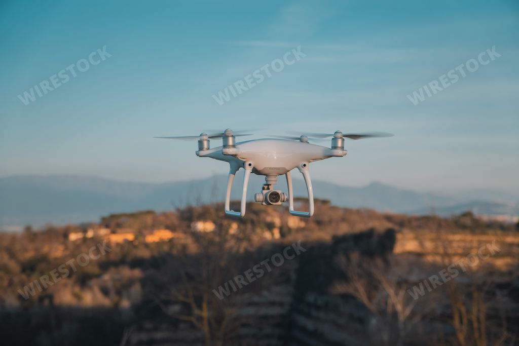 A big white drone in hovering with constructions in blurred background in Rome, Italy