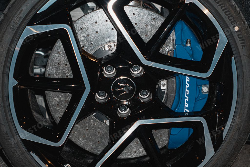 A closeup shot of a wheel of Maserati MC20 at night