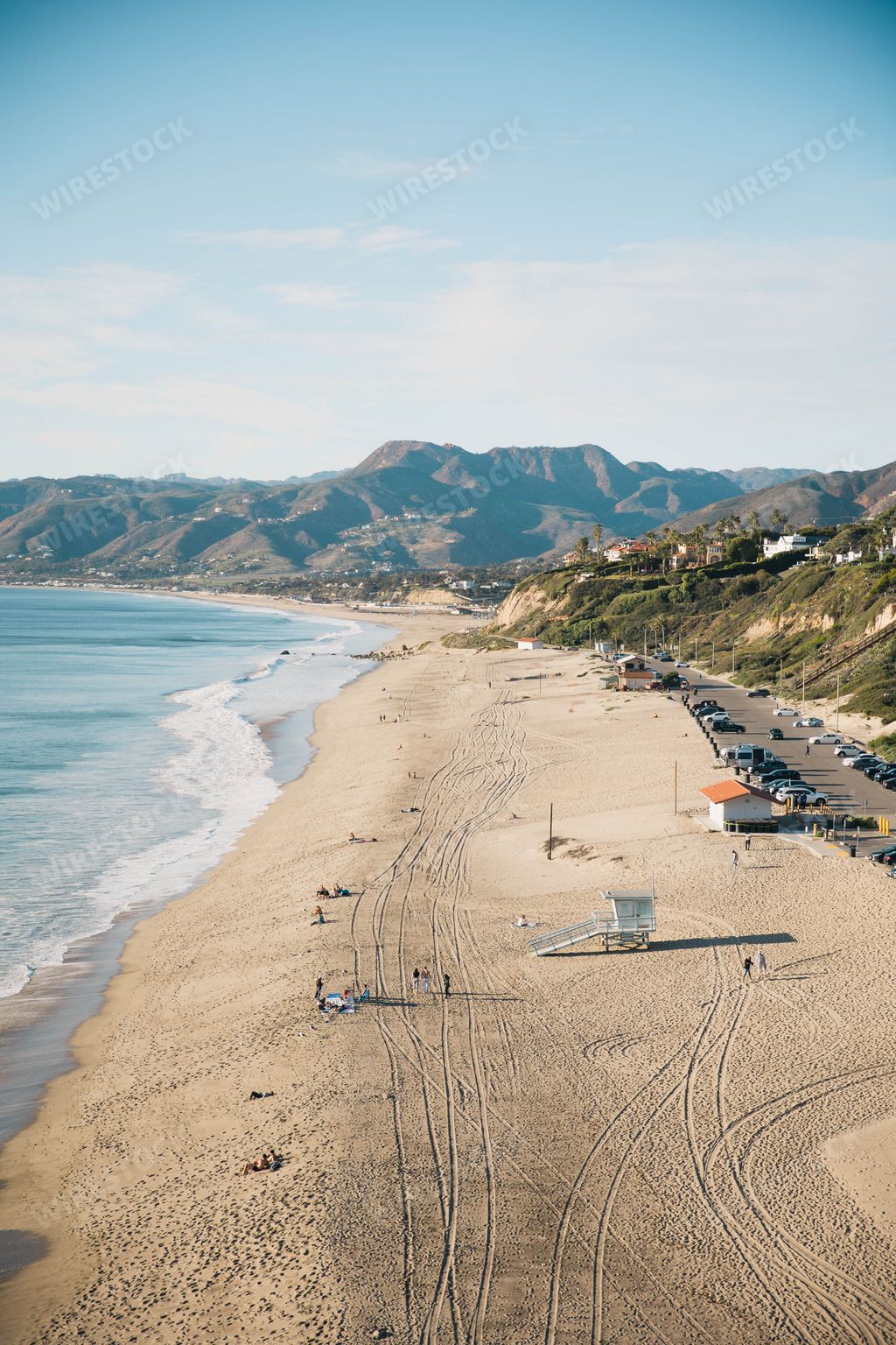 An aerial view of Zuma Beach and mountains against blue sky on a sunny day in Malibu, California, United States