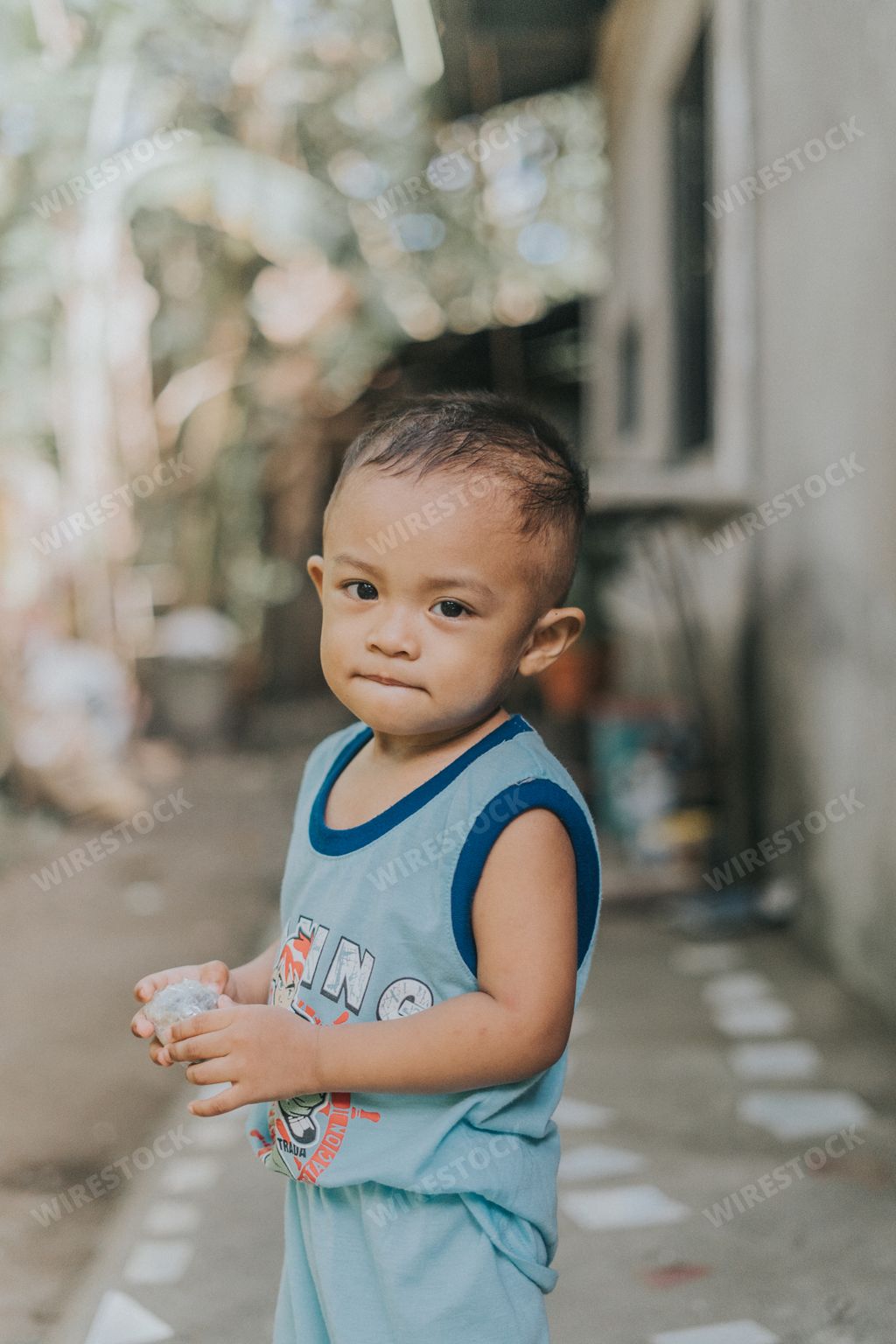 Portrait of a Cute and Happy Little Filipino Kid Smiling into the Camera. Young Filipino boy in nature, park or outdoors playing Games.