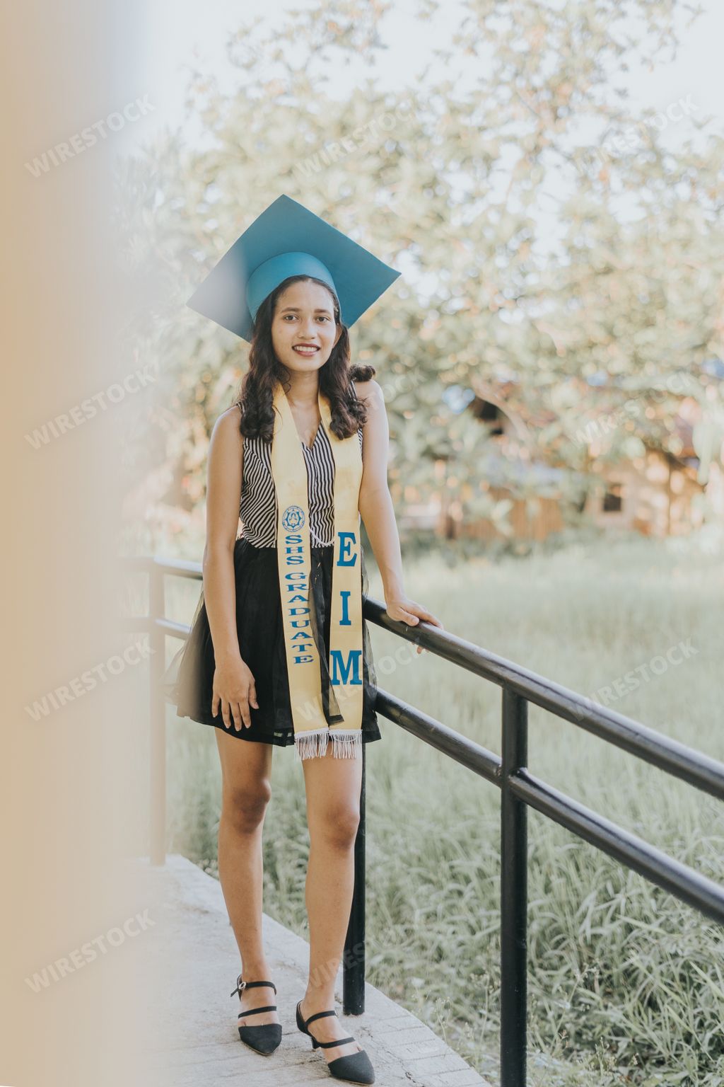 Beautiful Portrait of a Pretty Asian Filipino Woman in her Graduation Cap, Gown, and Sash. Senior Class on University Campus in the Philippines