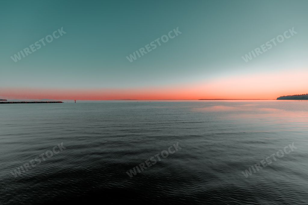 A bright blue pink sunset sky over a calm sea