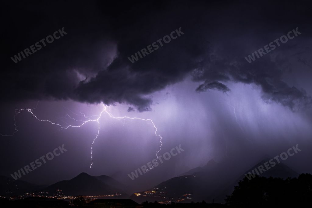 Landscape view of a thunderstorm with lightning bolts over a mountain range in the region of Montreux Switzerland