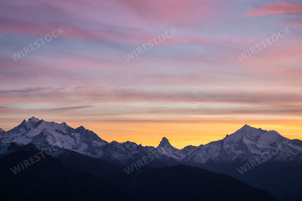 Landscape view of a soft sunset over a mountain range in Switzerland with the Matterhorn in the middle