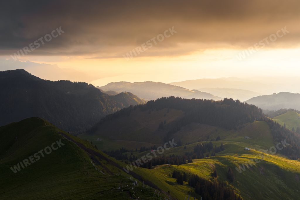 A beautiful spring landscape view of mountain layers and the Geneva lake illuminated by a gorgeous sunset light