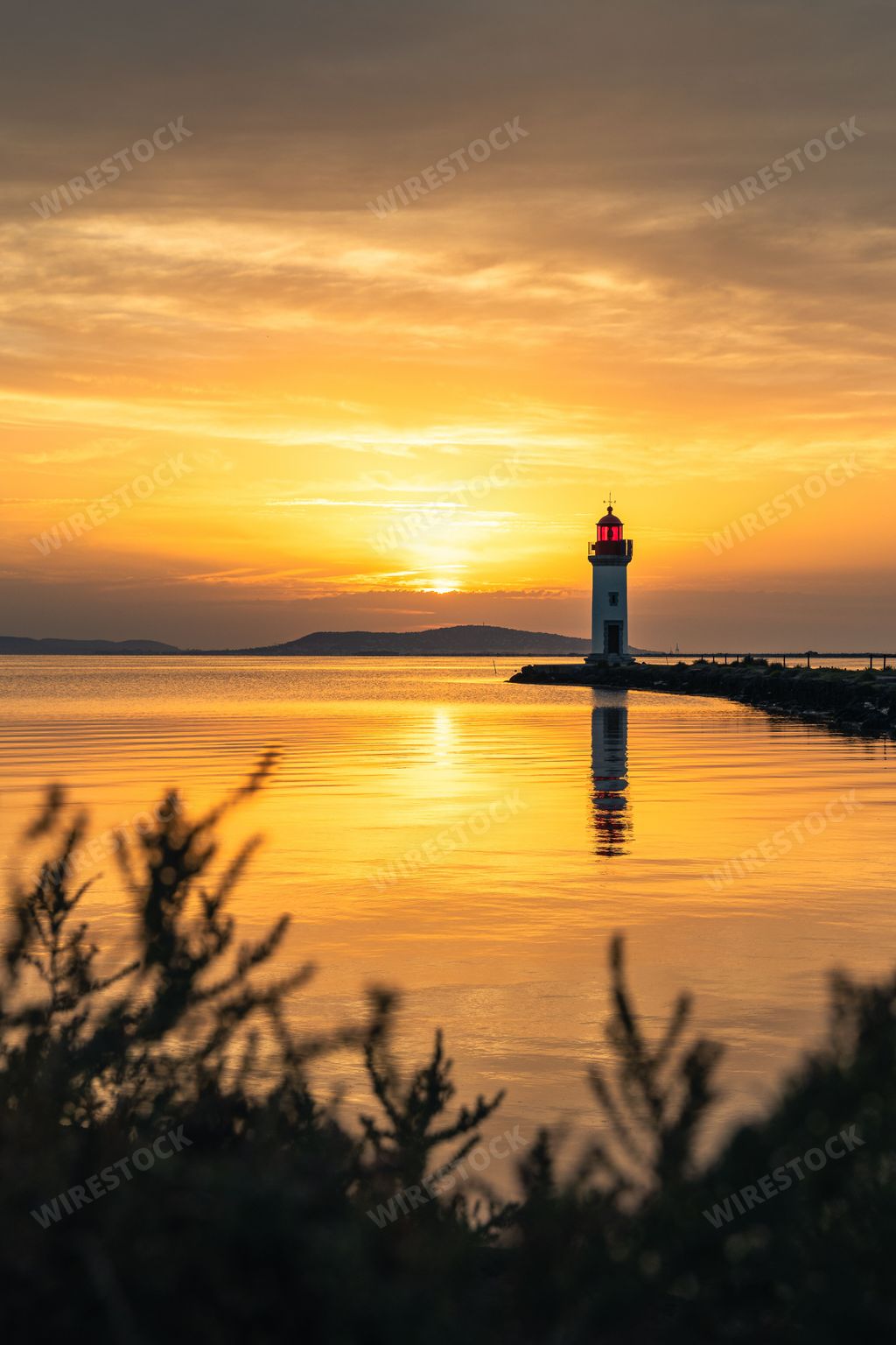 A vertical shot of the Les Onglous lighthouse in Marseillan, Herault, France during sunset