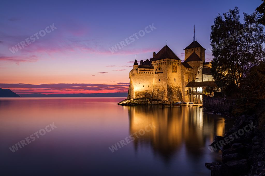 The famous and beautiful Chillon Castle reflecting in the Geneva Lake at sunset, in Veytaux Switzerland