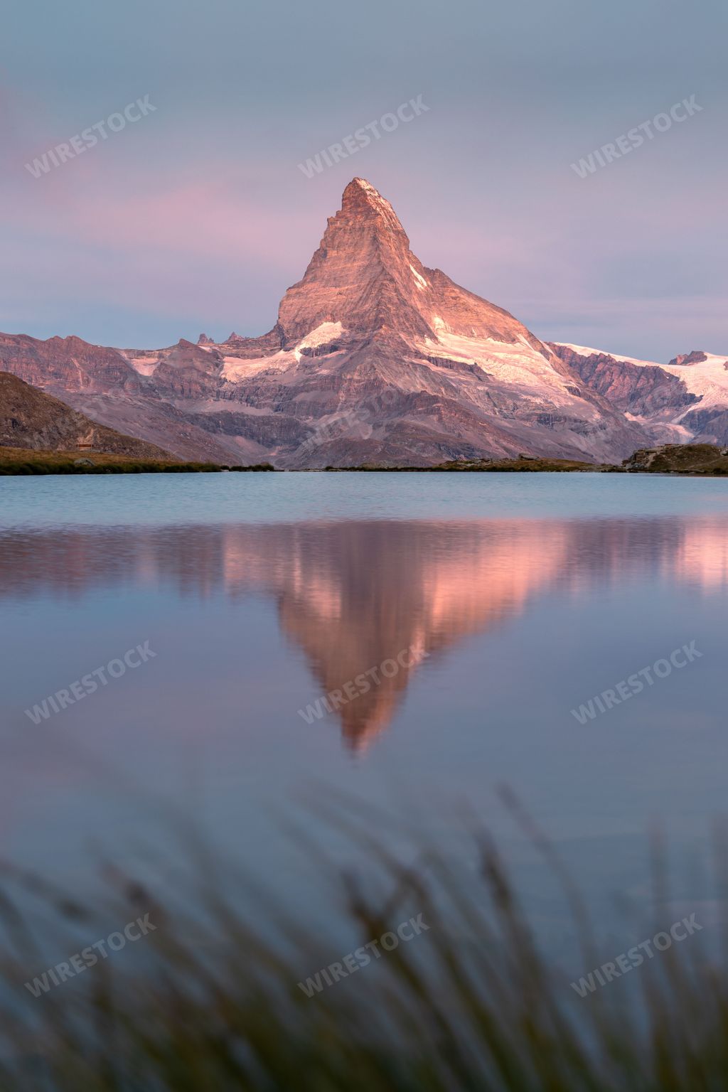 Reflection of the Matterhorn mountain in the Stellisee lake at sunrise in Zermatt Switzerland with a peaceful and colourful atmosphere