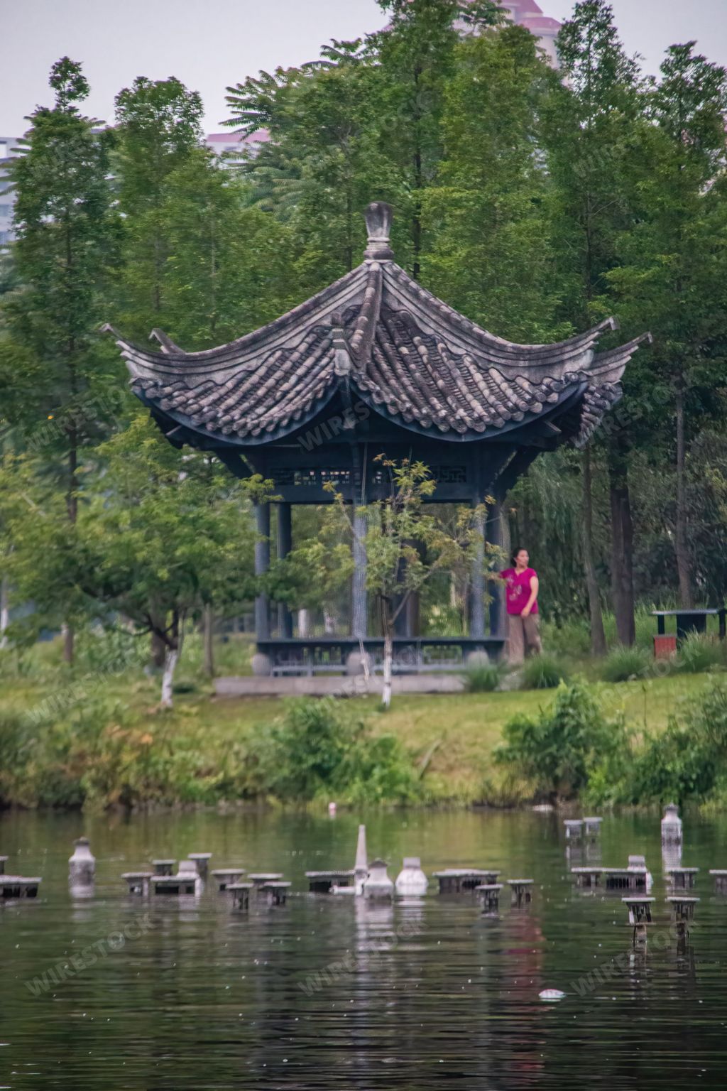 A vertical shot of small Chinese pagoda in Dongpo Urban Wetland Park near Minjiang river, Meishan city