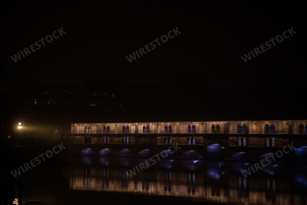 The panoramic view of the illuminated Vauban Dam reflected in the river in Strasbourg, France at night