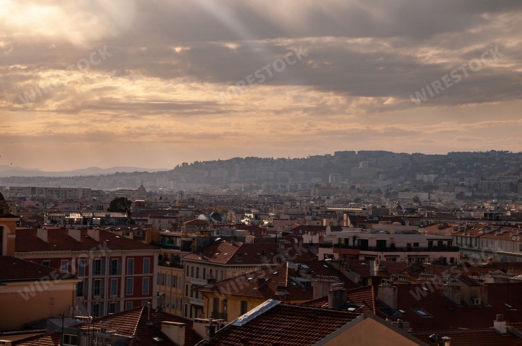 An aerial view of the beautiful sunset in overcast weather over the city with red tile roofs
