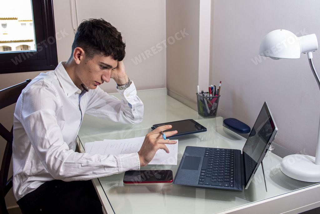 A Caucasian man working in the office with a laptop