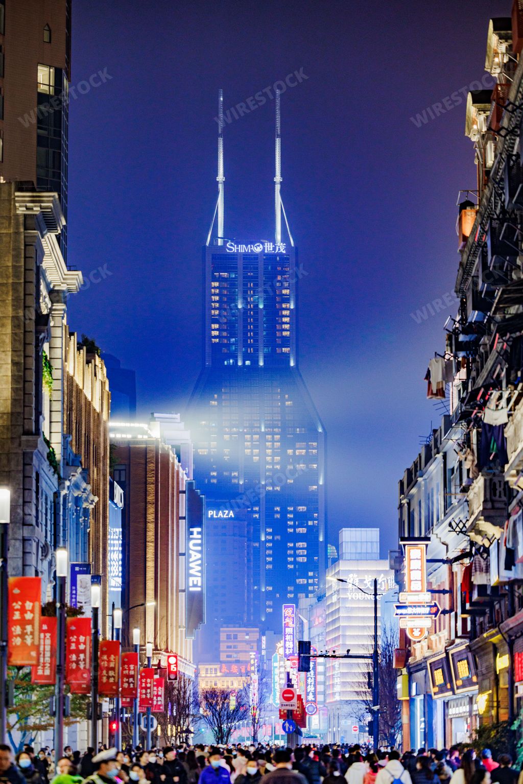 A vertical shot of the illuminated Shimao International Plaza building in Shanghai, China