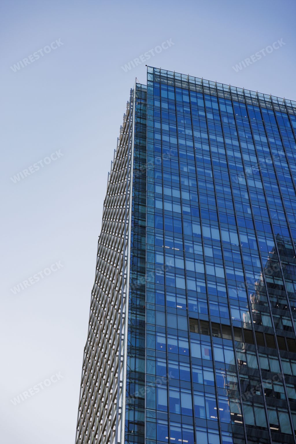 A vertical low angle shot of a tall blue glass modern skyscraper in Shanghai, China