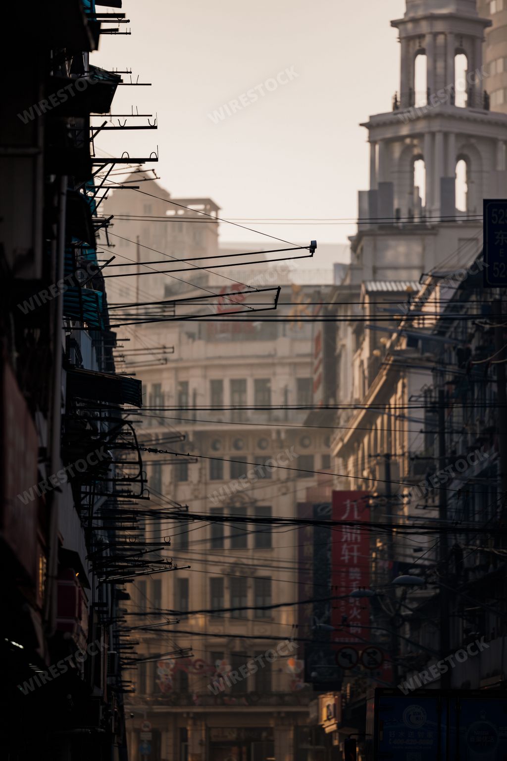 A vertical shot of overhead cabels in Shanghai city with buildings in the background