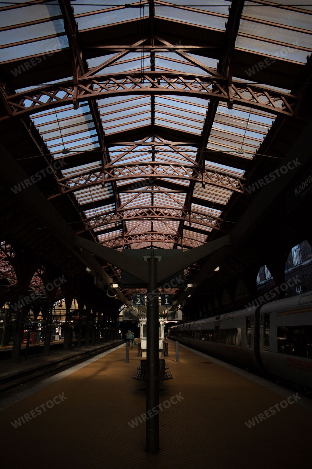A vertical shot of an indoor train station in Copenhagen with glass on the ceiling