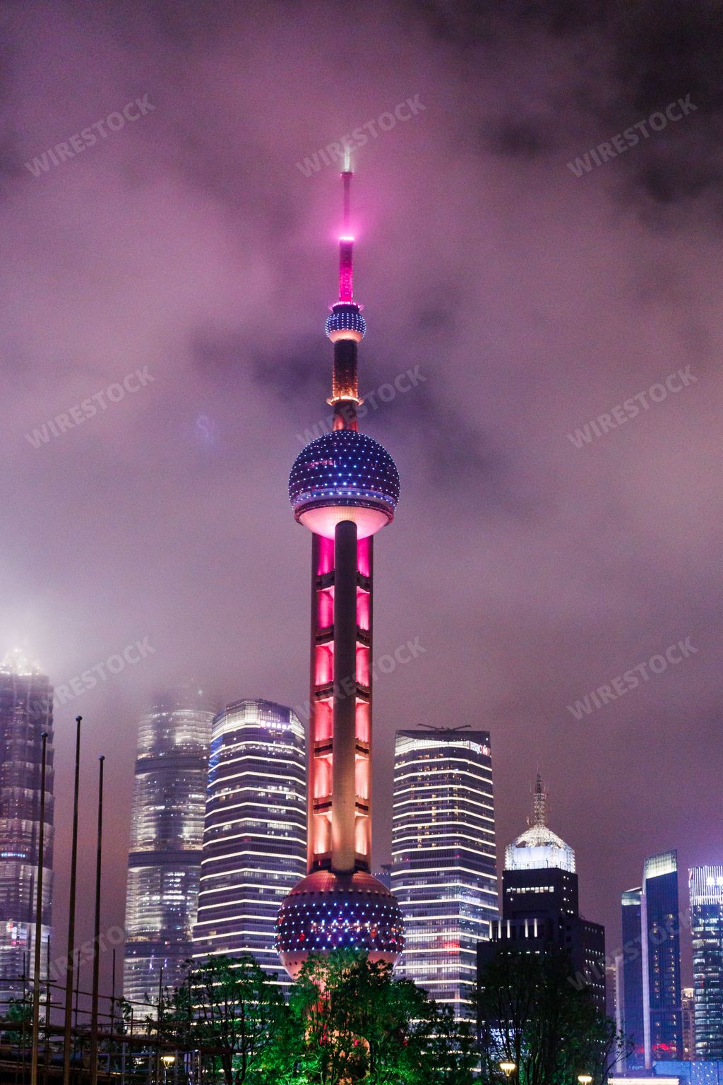 A vertical shot of the illuminated Oriental Pearl TV Tower at night in Shanghai, China