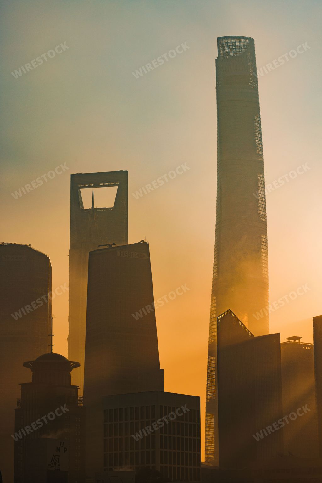 A vertical shot of Pudong Skyline skyscrapers by the river during sunrise in Shanghai