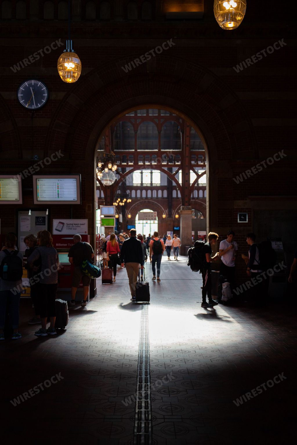 A vertical shot of people in a train station in Copenhagen