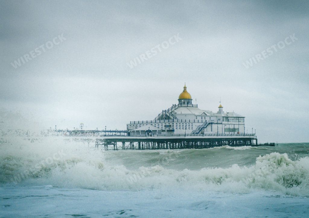 A view of Eastbourne Pier in England with strong waves in the ocean