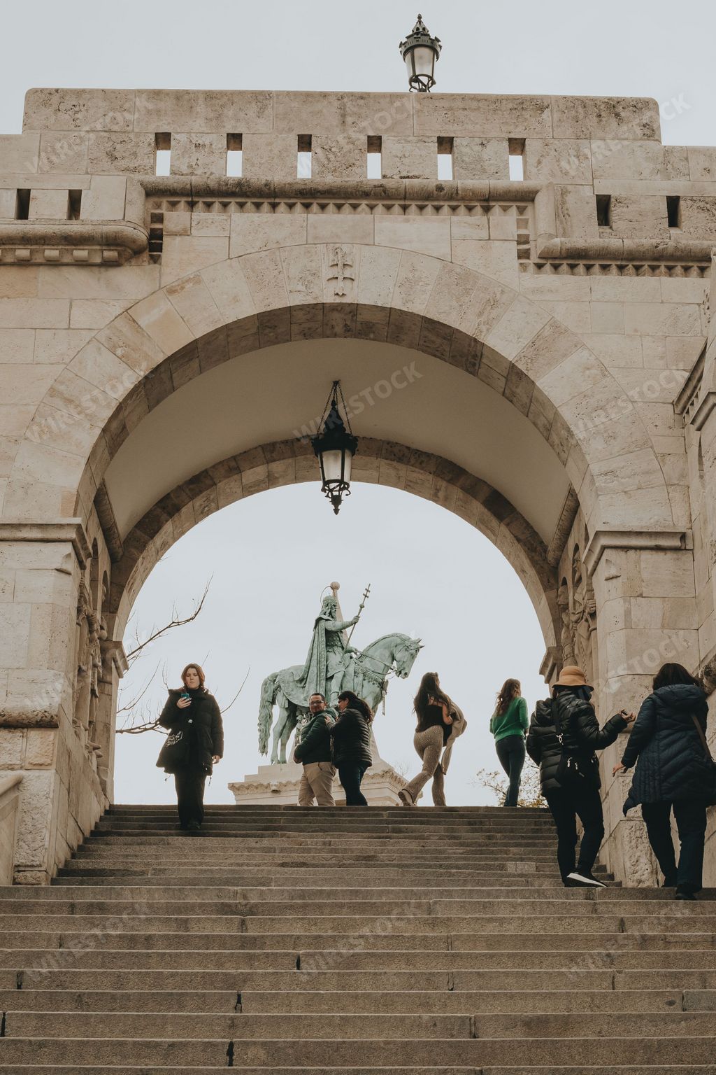 A low angle shot of an arch in the Fisherman's bastion with a statue in the background