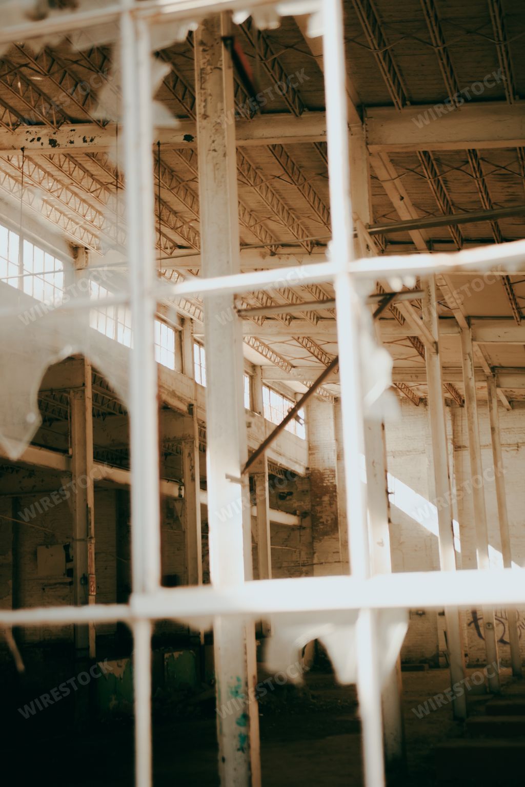 A vertical shot of the view through a broken window of an abandoned building room