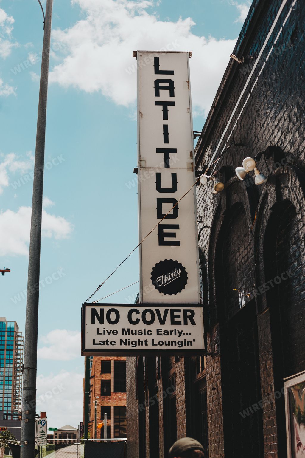 A vertical shot of a bar sign with Latitiude text in Austin, Texas in the USA