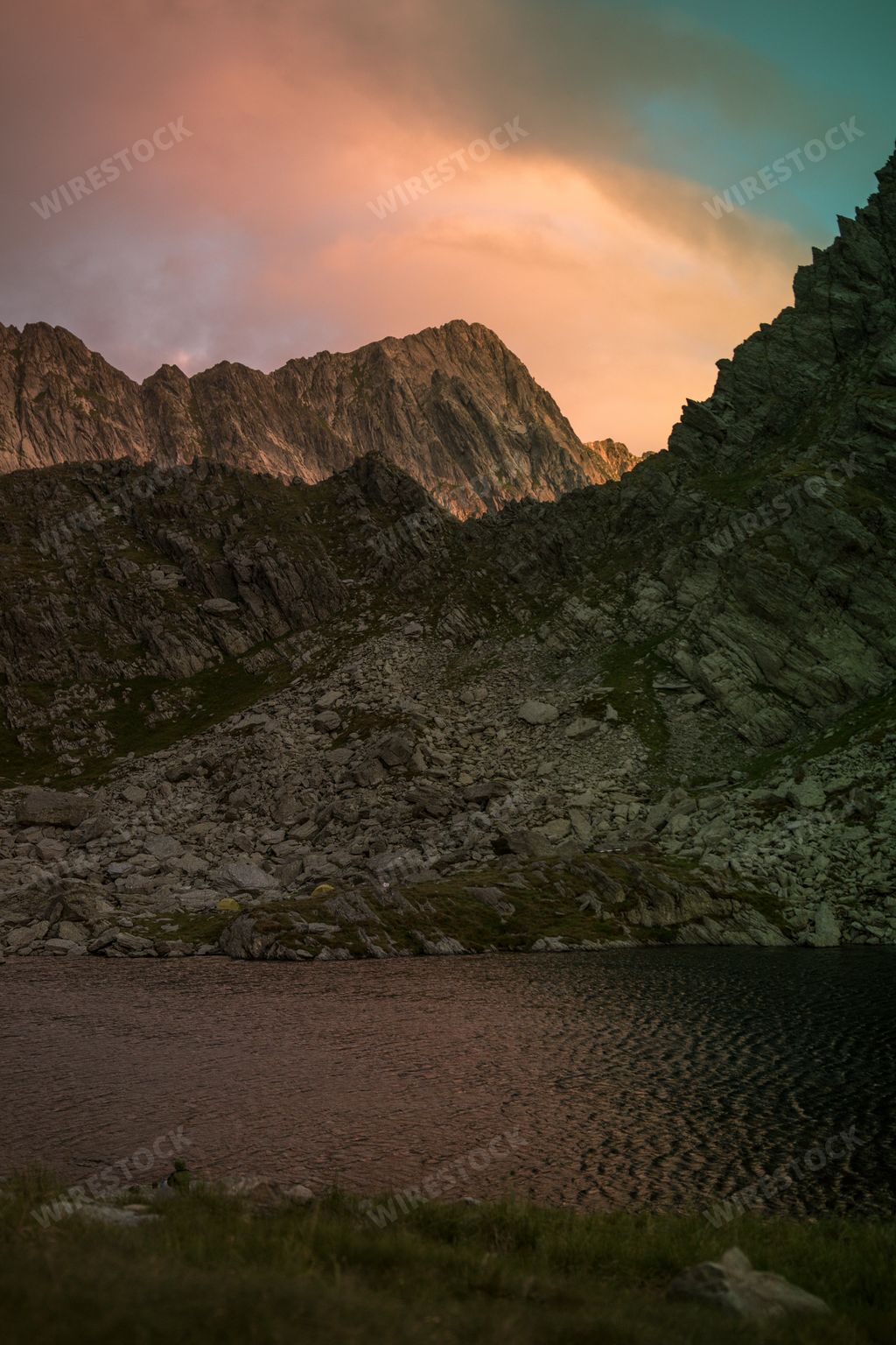 A vertical shot of mountains and fog during the sunset