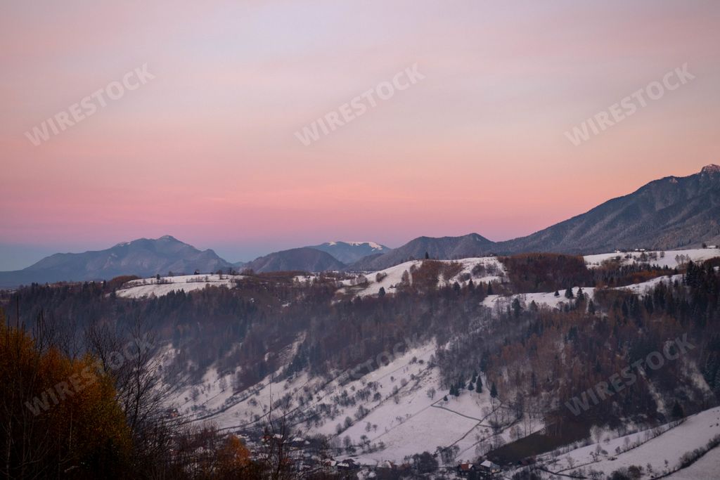 A mesmerizing scenery of snowy hills at sunset